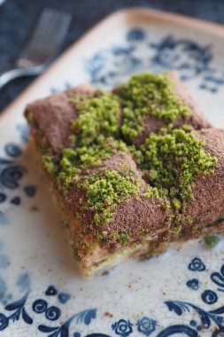 Şam fıstığı kırıntılarıyla serpiştirilmiş otantik baklava dilimlerinin tadını çıkarın.