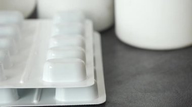 Masadaki konteynırların yanında bir ilaç paketine yakından bak..