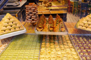 Bir pazar ortamında renkli bir dizi baklava ve şeker sergilendi..