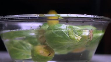 Taze Brüksel lahanaları temizlenmesi için suda durulanır..