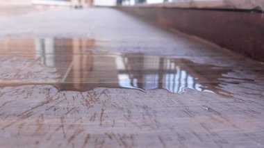 Su, bir iç mekanda pürüzsüz bir zemin yüzeyinde birikir..