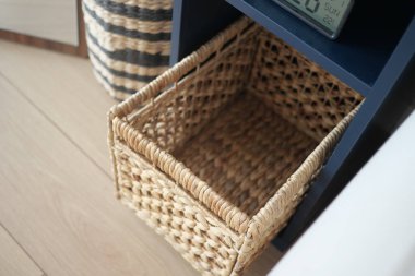 Konforlu bir odada, karanlık bir rafta boş duran bir sepet..