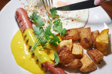 Yağda yumurta, sosis ve çıtır patatesli lezzetli kahvaltı tabağı..