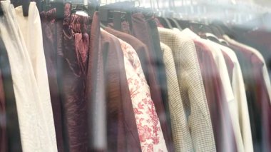 Lüks bir butik vitrininde asılı moda kıyafetlerin koleksiyonu..