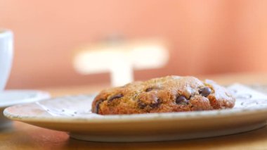 Yeni pişmiş çikolatalı kurabiye, yanında kahve olan bir tabakta duruyor..