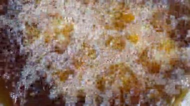 Sıcak su kahve telvesinin üzerine dökülüyor, zengin kabarcıklar ve aroma yaratıyor..