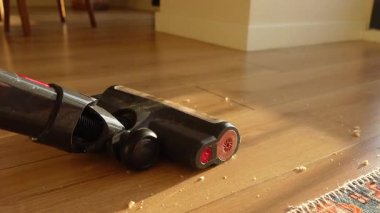 Elektrikli süpürge, parke zemindeki kırıntıları temizlemek için kullanılır..