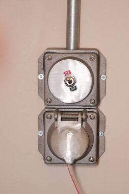 Elektrik düğmesi bir duvara monte edilmiş açılır ve kapanır ayarları gösterir.