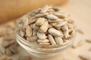 Taze ayçiçeği tohumları tahtadaki cam kasede sergilenir..