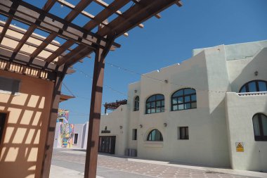 Parlak renkli binalar, güneşli bir kasabada yol boyunca uzanır..