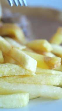 Taze pişmiş altın patatesler sosla sunulur..