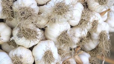 Taze sarımsak soğanları bir yaz marketinde üst üste yığılmış müşterileri davet ediyor..