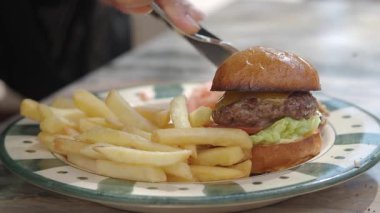 Lezzetli hamburger, taze malzemeler ve yerel bir lokantada kızarmış patates..