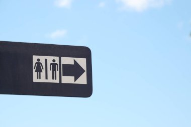 İşaret, sağı gösteren bir okla tuvalet sembollerini gösteriyor..