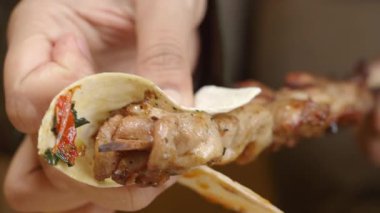 Lezzetli ızgara et soslu sıcak bir tortillanın içine konuyor..