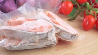 Olgun domateslerle paketlenmiş somon filetoları pişirme hazırlıkları için hazır..