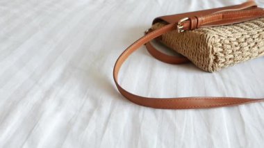 Moda dokuma bir çanta yumuşak beyaz bir yüzeye dayanır ve tasarımı sergilenir..