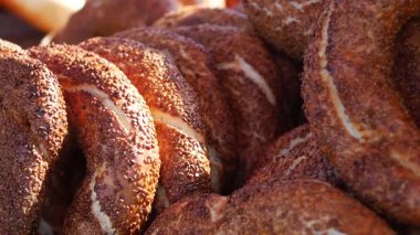 Müşteriler İstanbul 'daki hareketli bir sokak satıcısından sıcak bir simit yiyor.