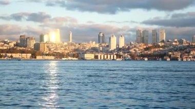 Güzel alacakaranlık renkleri suyu yansıtıyor, şehir binalarını gösteriyor..