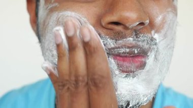 Bir insan tıraş kremini evde tımarlanmaya hazırlanmak için kullanır..