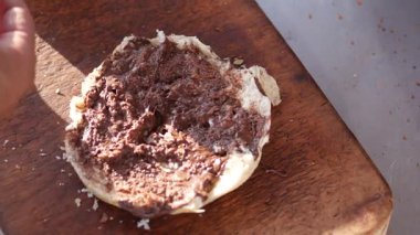 Tadını çıkarmak için yumuşak ekmeğe sürülmüş lezzetli bir çikolata hazırlıyorum..