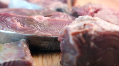 Tüccarlar kalabalık bir sahil pazarında müşteriler için taze balık hazırlıyorlar..