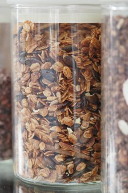 Mutfak rafında granola dolu bir kavanoz sergileniyor..