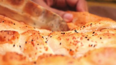 Lezzetli ekmek çeşitli malzemelerle dilimleniyor..