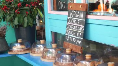 Canlı bir kafe, cam kubbelerin altında bir dizi vegan tatlısını sergiler..