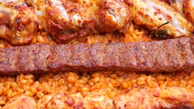 Sulu ızgara tavuk ve lezzetli kebap aromalı pilavın üstünde oturur..