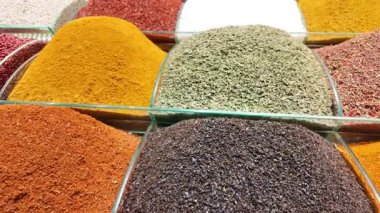 Hareketli pazar tezgahlarındaki konteynırlarda düzenlenmiş canlı baharatları keşfedin.