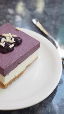 Mor katmanlı ve malzemeli lezzetli bir tatlı rahat bir kafede yenir..