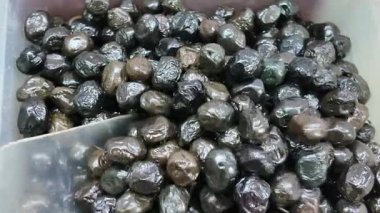 kaşık plastik kaseden siyah zeytin koparır. .