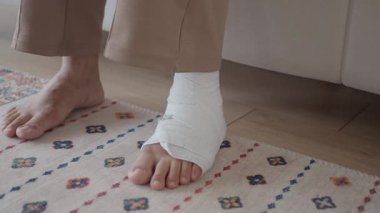 Bir insan, sıcak bir odadaki renkli bir halıya sarılı bir ayağını koyar..