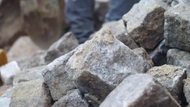 İşçiler, bölgeye sağlam bir yol açmak için taş döşüyorlar..