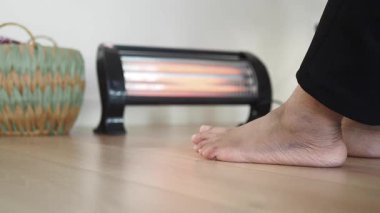 Ayaklar ısıtıcının yanında rahatlarken sıcak bir atmosferin tadını çıkarıyor..