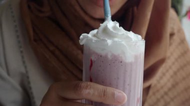 Sıcak bir ortamda çırpılmış kremayla meyveli bir içkiden hoşlanan bir insan..