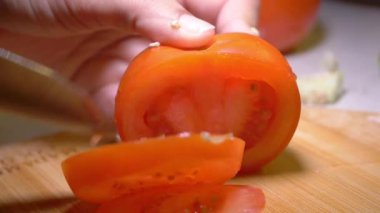 Lezzetli bir yaz salatası için taze, olgun domates dilimleme sürecinin tadını çıkar..