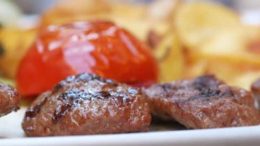 Kızarmış domates ve kızarmış cips ile birlikte sulu ızgara et..