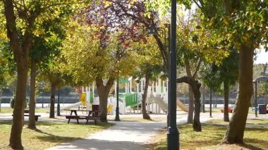 Aileler ve çocuklar bir park ortamında oynarken ve dinlenirken eğleniyorlar..