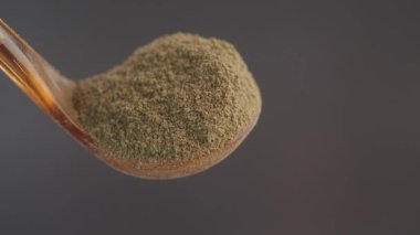 Bir kaşığın üzerindeki bitkisel toz yakın plan, deseni ve rengi gözler önüne seriliyor..