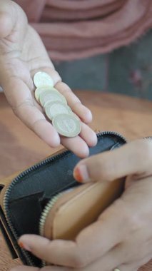 Bir kafede bir kişi cüzdanından bozuklukları ayırıyor..