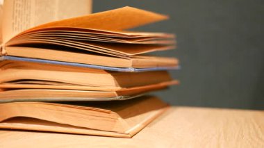 Eski kitaplar ahşap bir masada, cazibelerini sergiliyorlar..