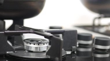 Gaz ocağı ocağının yakın çekim görüntüsü, pişirme etkinliğini vurguluyor.