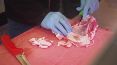 Becerikli kasap, et kesme tahtasındaki eti ustalıkla keser..