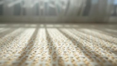 Güneş ışığı karmaşık örülmüş bir yüzey boyunca akar ve desenler yaratır..
