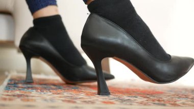 Kadınlar siyah topuklularla siyah çorapları benzersiz bir görünüş için eşleştirirler..