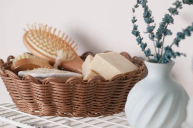 Şık sepetin içinde çiçekli vazo ve sabun var..