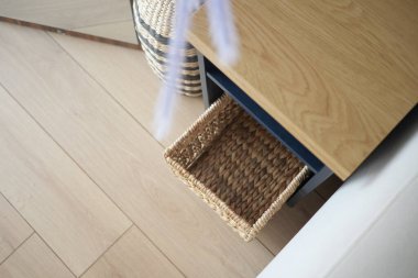 Konforlu bir ortamda, ahşap bir masanın içine örülmüş bir sepet konur..