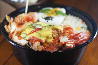 İçinde pirinç, taze sebze ve sos bulunan tuzlu tavuk kasesi..